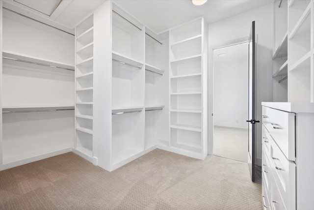 walk in closet with light carpet