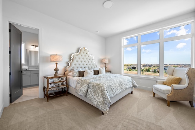 bedroom with light colored carpet and ensuite bath