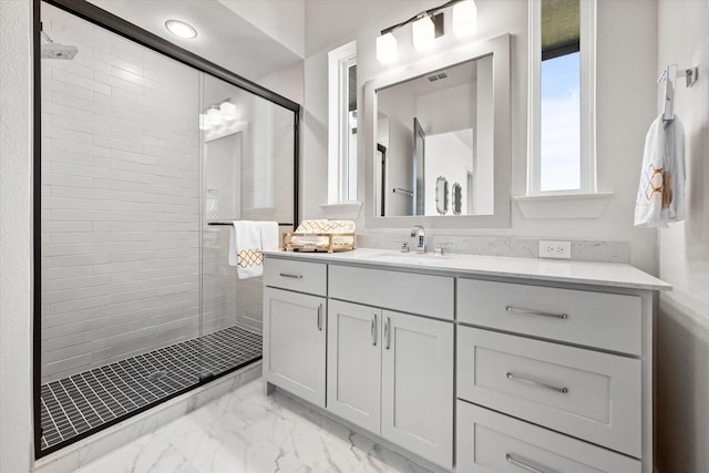 full bath featuring marble finish floor, a shower stall, and vanity