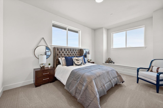 carpeted bedroom featuring multiple windows and baseboards