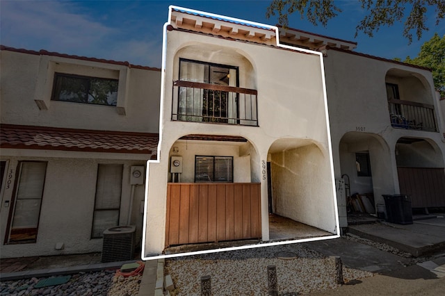 view of front of property with a balcony and central AC unit