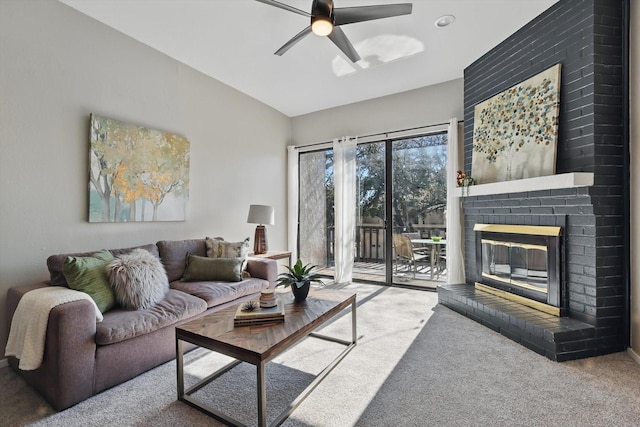 living area featuring lofted ceiling, a brick fireplace, carpet, and ceiling fan