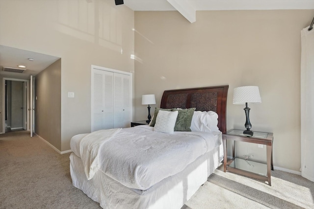 bedroom featuring beam ceiling, a closet, visible vents, light carpet, and baseboards