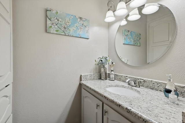 bathroom featuring a textured wall and vanity