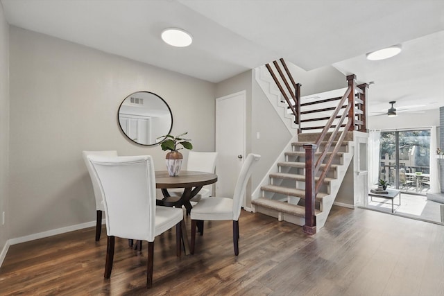 dining room with dark wood-style flooring, stairway, and baseboards