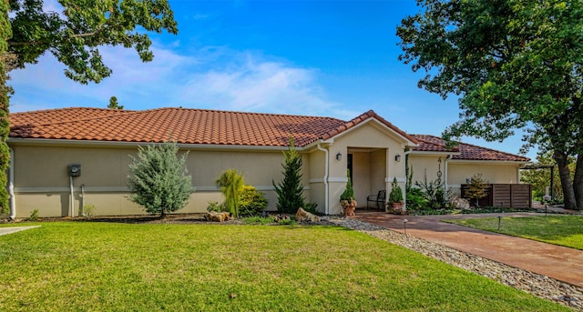 mediterranean / spanish home with a front yard