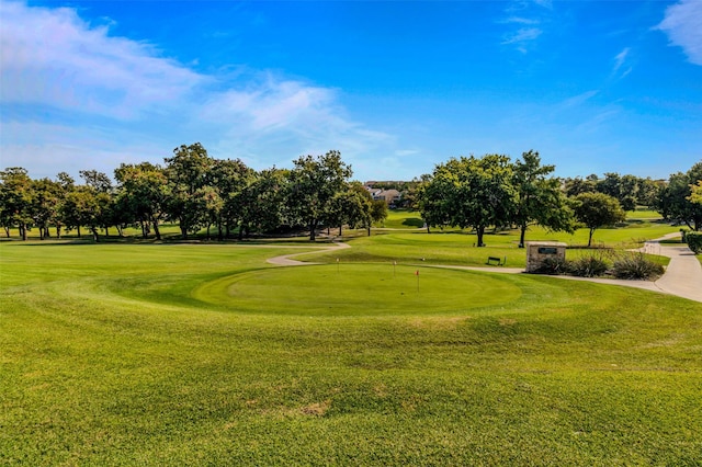 surrounding community featuring golf course view and a lawn