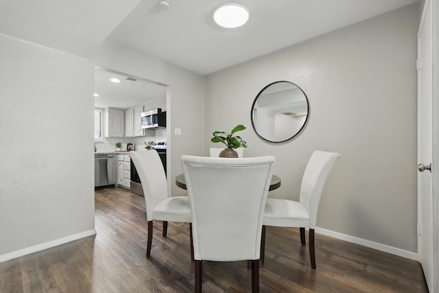 dining area featuring dark wood finished floors and baseboards