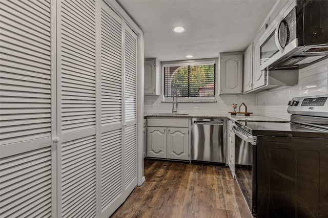 kitchen featuring dark wood-type flooring, appliances with stainless steel finishes, sink, and tasteful backsplash