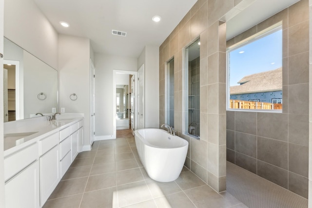 bathroom with shower with separate bathtub, vanity, and tile patterned floors