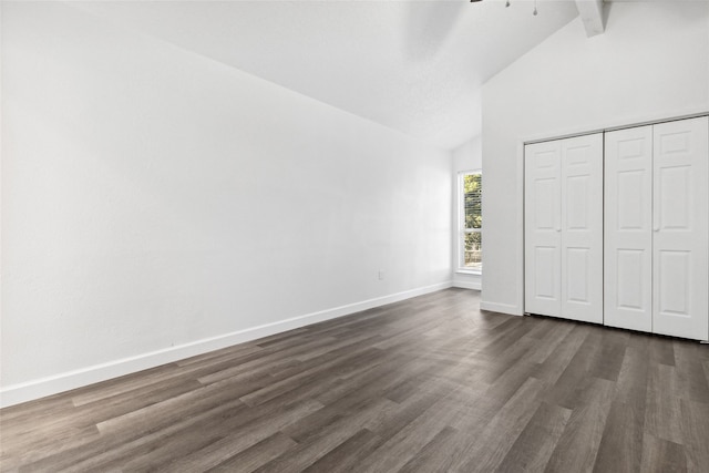 unfurnished bedroom featuring high vaulted ceiling, beam ceiling, dark wood-type flooring, and a closet