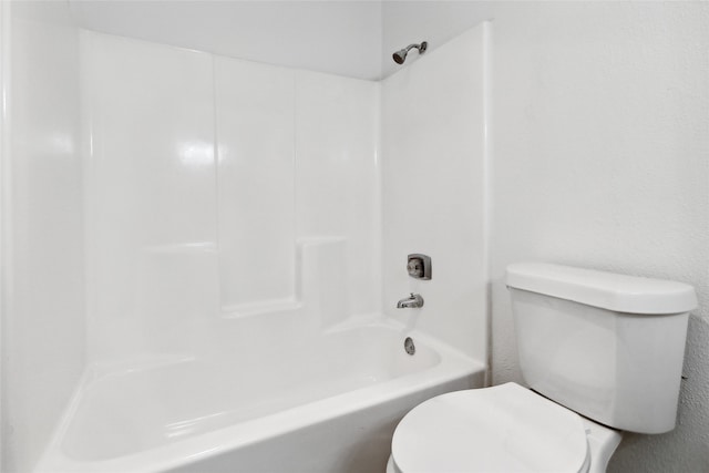 bathroom featuring washtub / shower combination and toilet