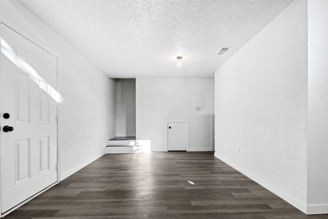 empty room featuring dark hardwood / wood-style floors and a textured ceiling