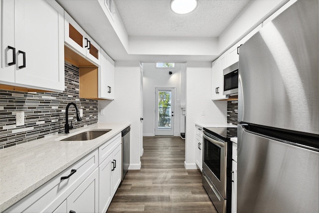 kitchen with sink, a textured ceiling, white cabinetry, appliances with stainless steel finishes, and dark hardwood / wood-style flooring