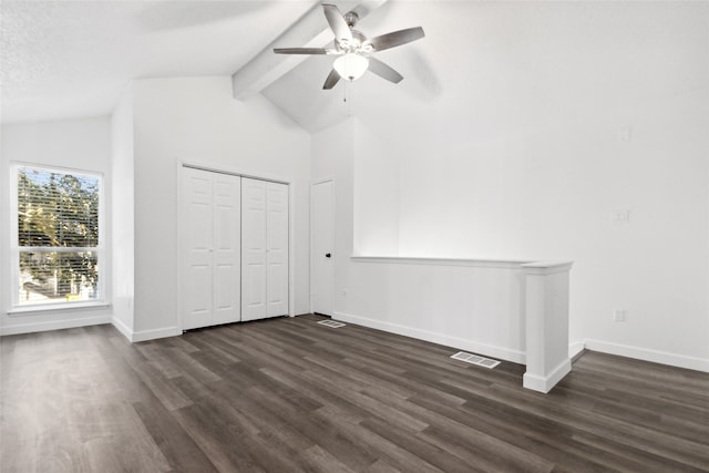 unfurnished bedroom with dark wood-type flooring, a closet, lofted ceiling with beams, and ceiling fan