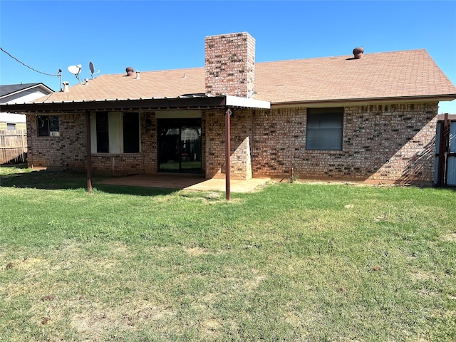 rear view of house with a yard and a patio