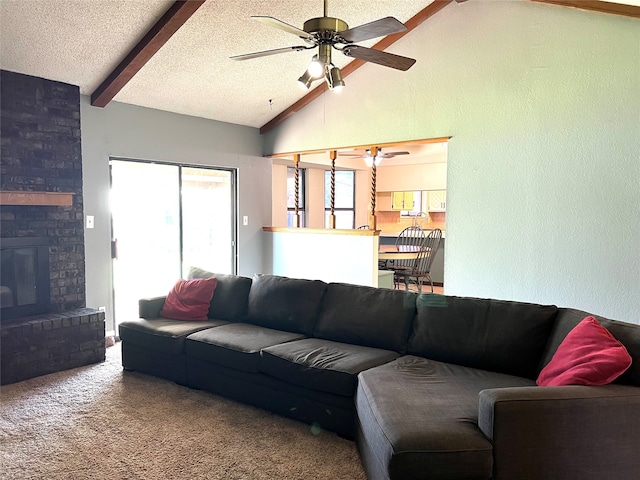 carpeted living room with a fireplace, ceiling fan, vaulted ceiling with beams, and a textured ceiling