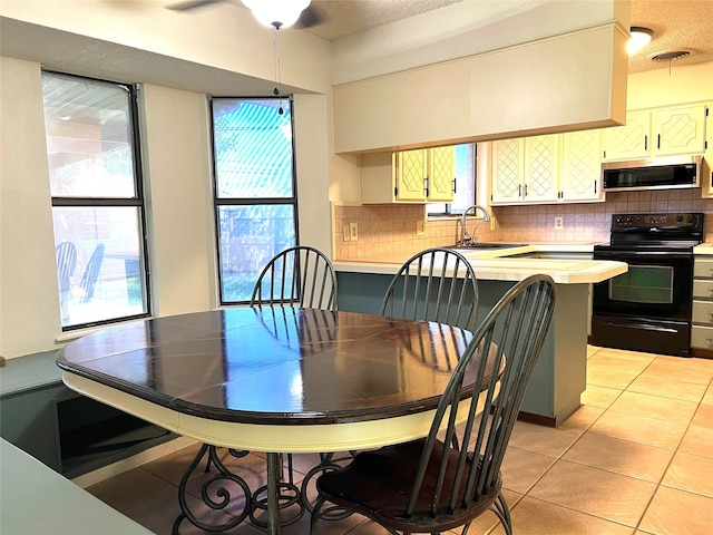 tiled dining space with plenty of natural light, sink, and a textured ceiling