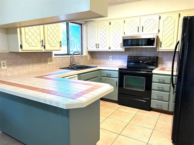 kitchen featuring black appliances, tasteful backsplash, sink, kitchen peninsula, and tile counters