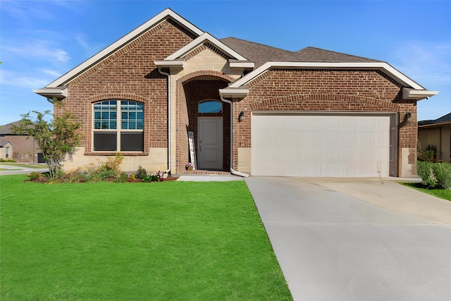 view of front facade with brick siding, an attached garage, concrete driveway, and a front yard