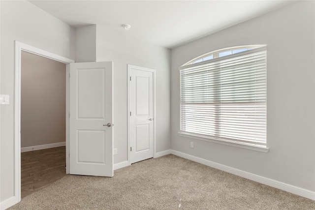 unfurnished bedroom with a closet and light colored carpet