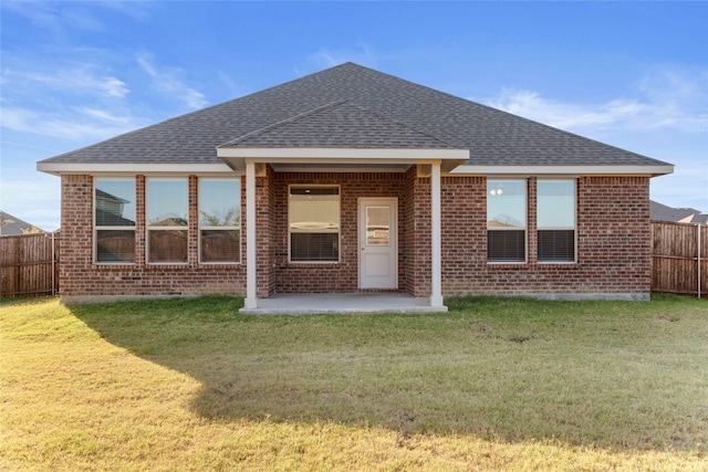 back of property featuring a lawn and a patio