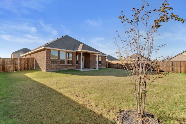 rear view of house featuring a yard