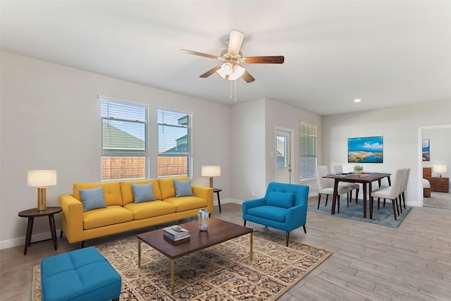 living room featuring light hardwood / wood-style flooring and ceiling fan