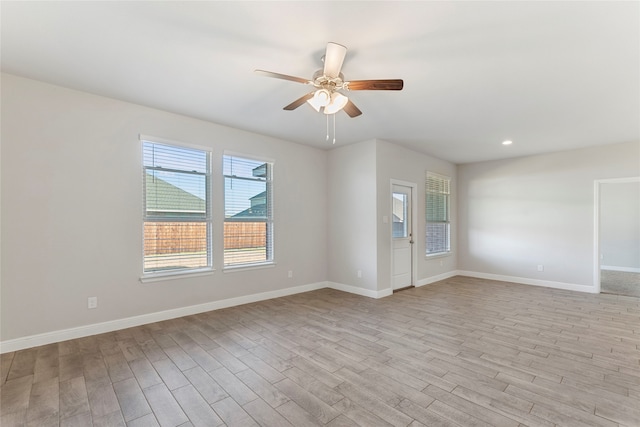 spare room with ceiling fan and light wood-type flooring