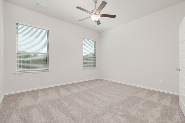 carpeted empty room with a healthy amount of sunlight and ceiling fan