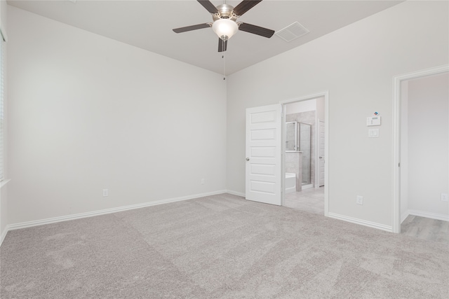 unfurnished bedroom with light colored carpet, connected bathroom, and ceiling fan