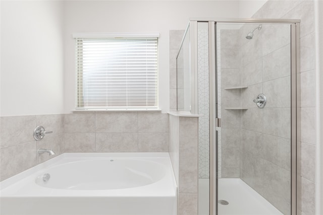 bathroom featuring shower with separate bathtub