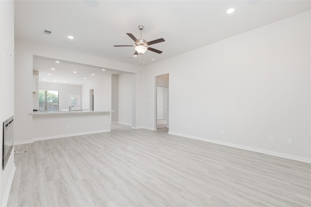 unfurnished living room with light hardwood / wood-style flooring and ceiling fan