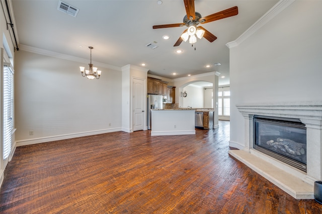 unfurnished living room with ceiling fan with notable chandelier, crown molding, and dark hardwood / wood-style flooring