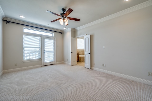 empty room featuring ceiling fan, crown molding, plenty of natural light, and light colored carpet