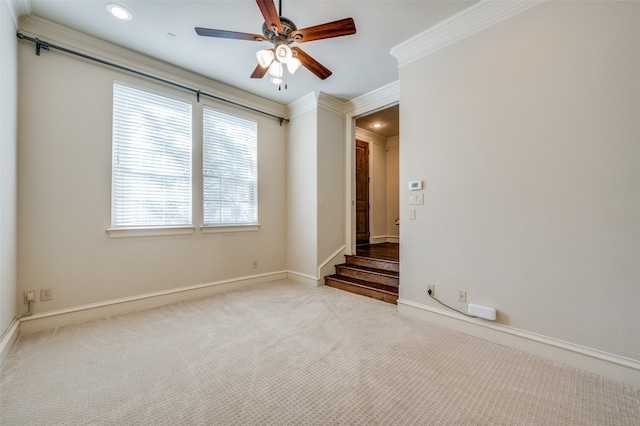 empty room featuring crown molding, ceiling fan, and light colored carpet