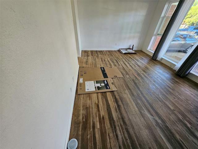 unfurnished room with dark wood-type flooring