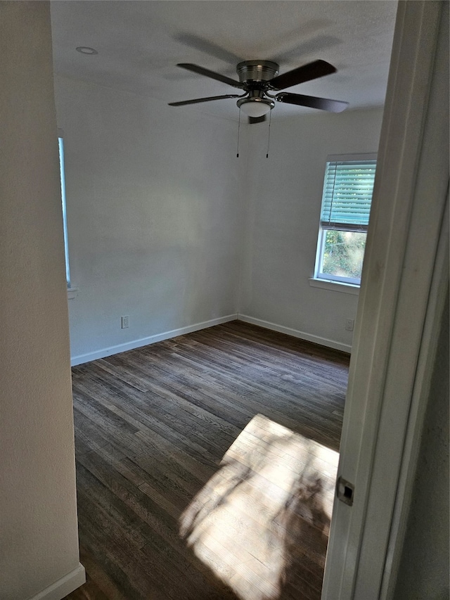 unfurnished room featuring dark hardwood / wood-style floors and ceiling fan