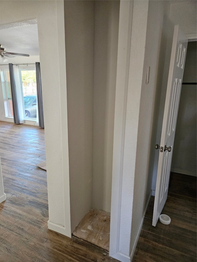 corridor featuring a textured ceiling and dark hardwood / wood-style floors