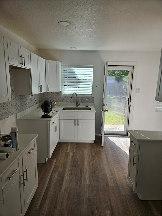 kitchen with dark hardwood / wood-style flooring, sink, white cabinets, and a textured ceiling