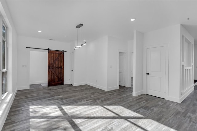 spare room featuring dark hardwood / wood-style floors and a barn door