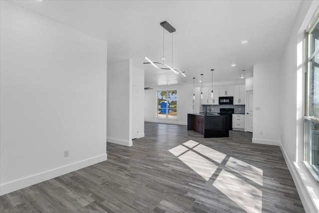 kitchen featuring a kitchen island, hanging light fixtures, tasteful backsplash, white cabinets, and dark hardwood / wood-style flooring