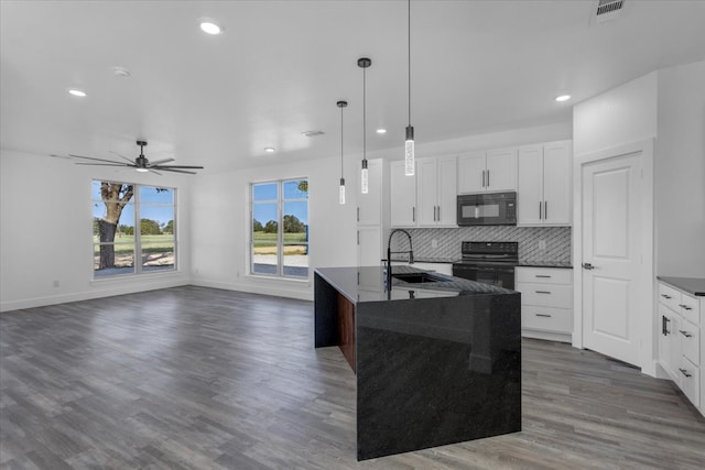 kitchen featuring dark hardwood / wood-style floors, sink, black appliances, decorative light fixtures, and white cabinetry