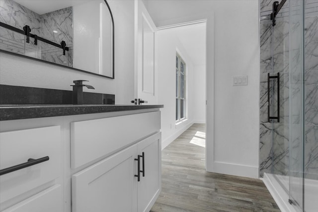 bathroom featuring vanity, wood-type flooring, and an enclosed shower