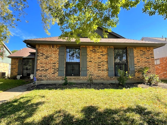 view of front of property with a front yard and central AC unit