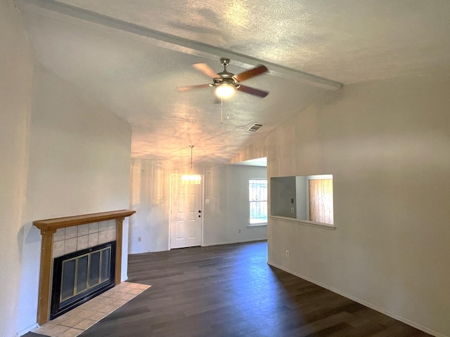 unfurnished living room with a fireplace, lofted ceiling with beams, a textured ceiling, hardwood / wood-style floors, and ceiling fan