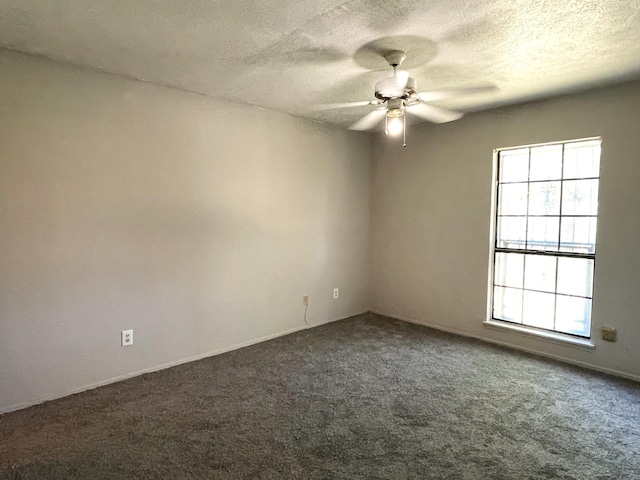 carpeted spare room featuring a textured ceiling and ceiling fan