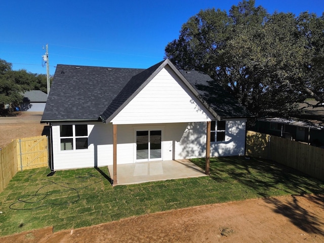 rear view of house featuring a patio area and a lawn