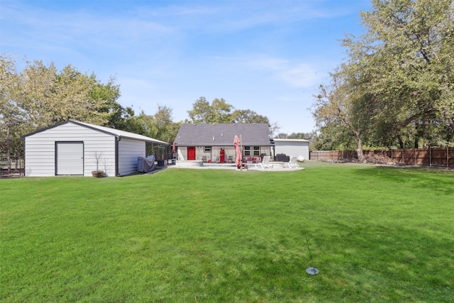 rear view of property with a patio, a yard, and an outbuilding