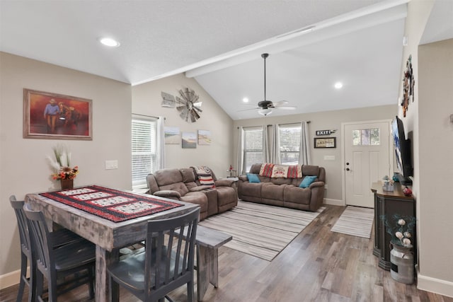 living room with ceiling fan, hardwood / wood-style flooring, and lofted ceiling